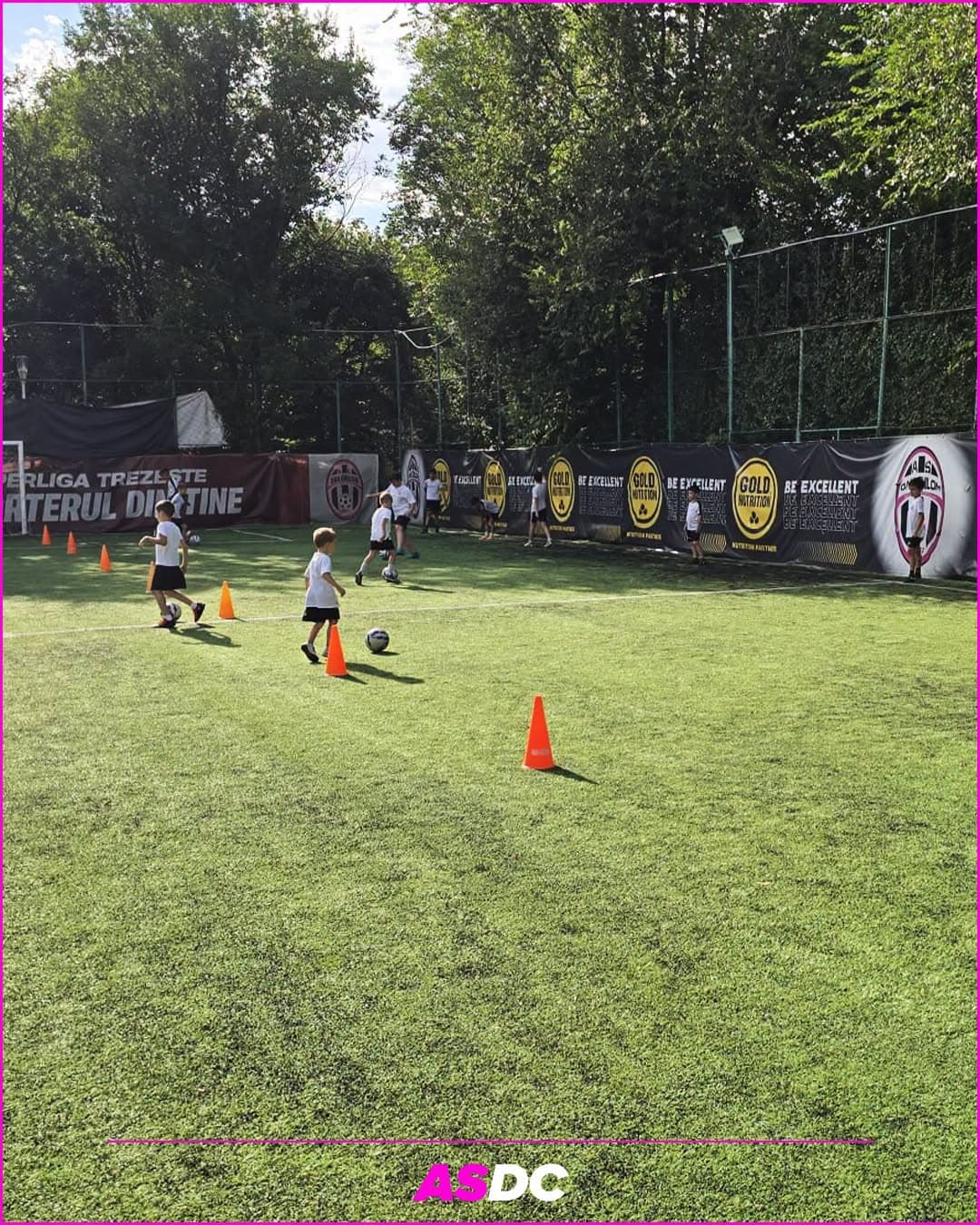 Copii care fac slalom printre conuri la antrenament